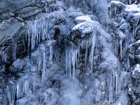 Felsnase umgeben von Eiszapfen und Eispanzer